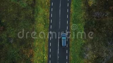 无人机顶视图摄像机跟踪<strong>黑色</strong>汽车行驶在空高速公路上，沿着多云的秋林进行<strong>大气</strong>道路旅行。